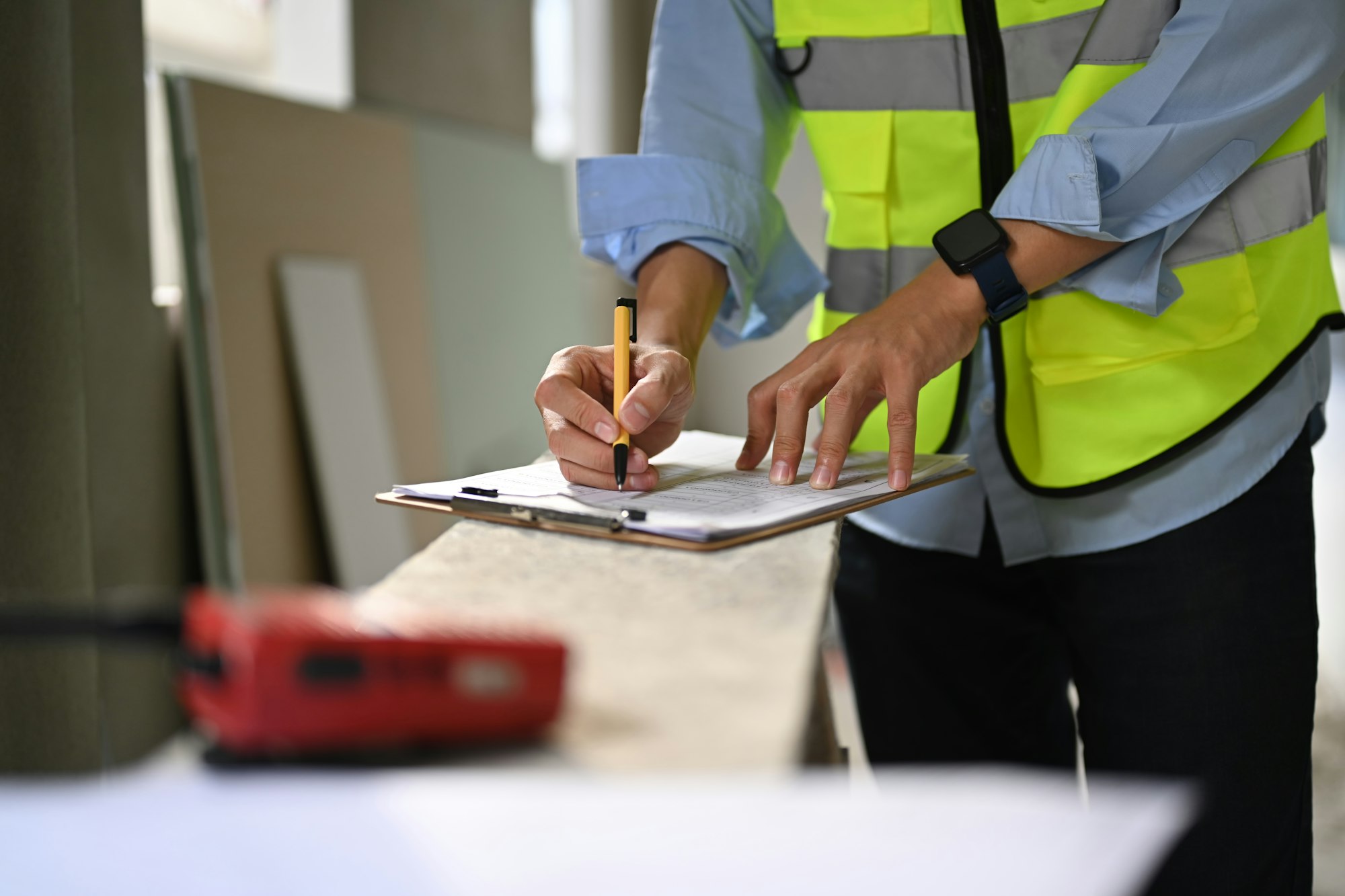 Engineer standing in construction site and checking building construction progress.